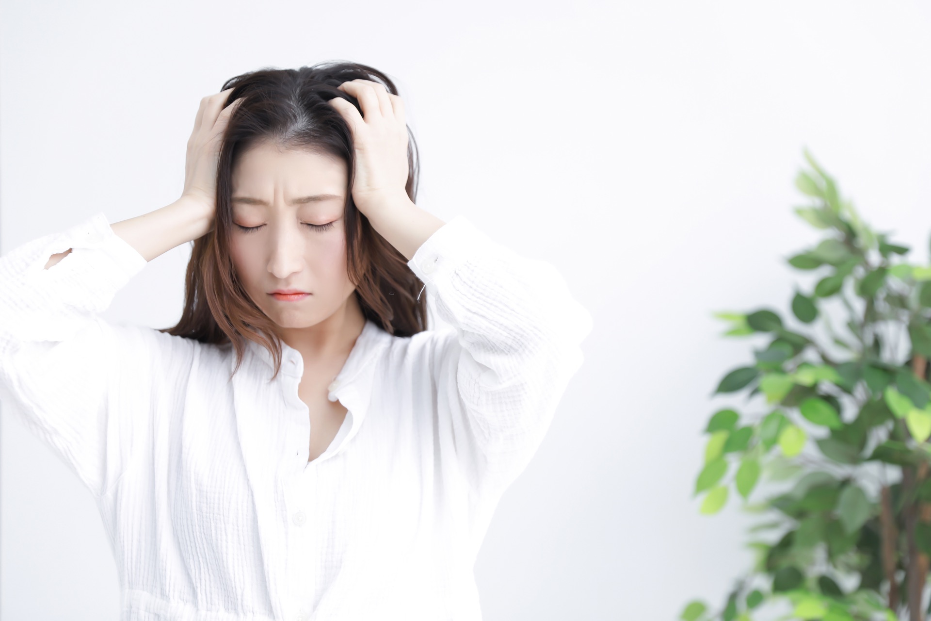 悩みを抱えて頭を抱える女性